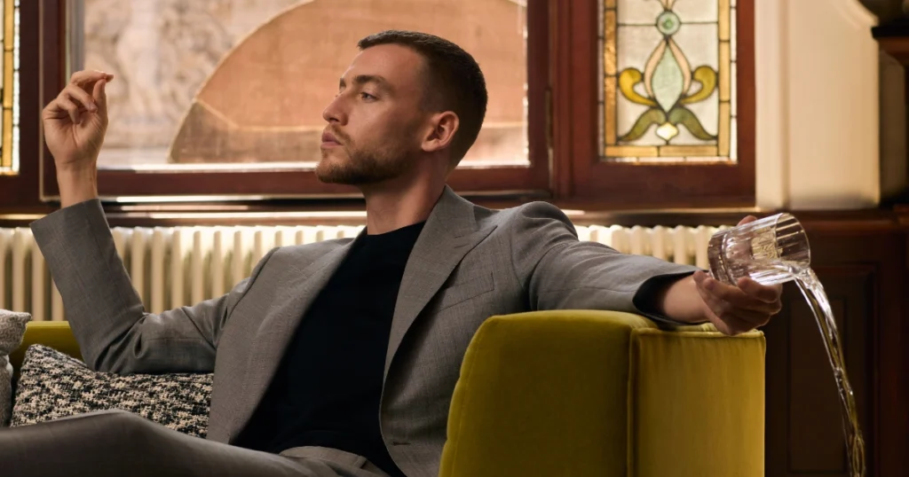 A Man is sitting while wearing the suit