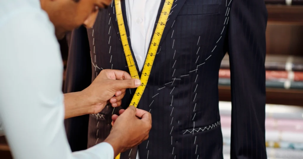 Tailor is helping wear suit to Customer
